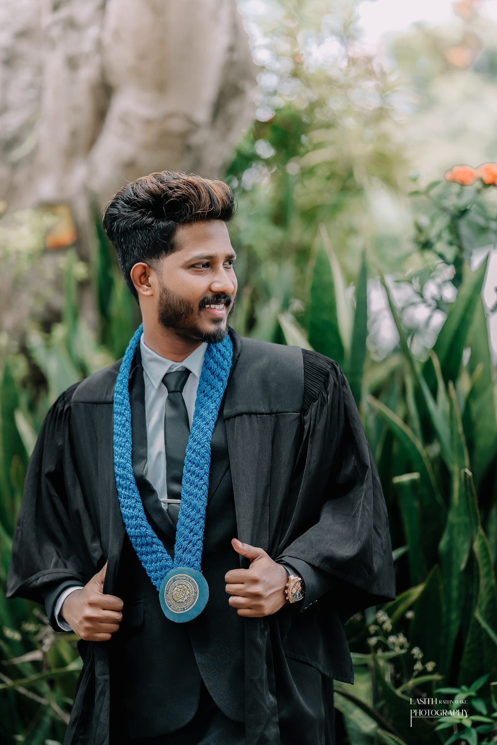 A graduate in his gown with his scroll, photo 1 of 7