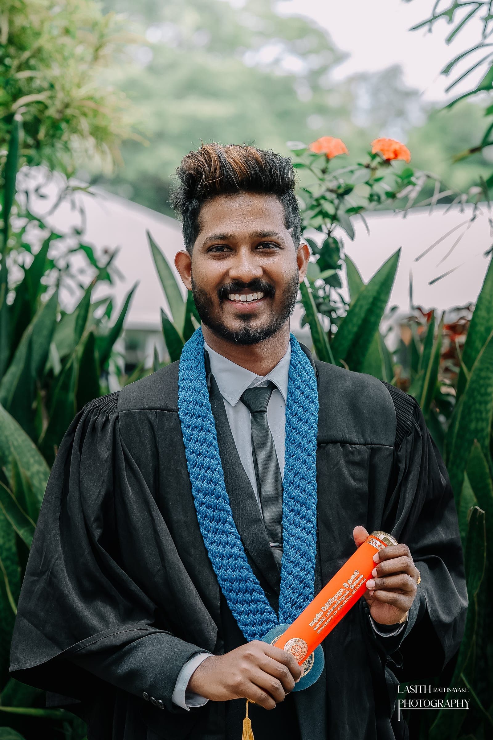 A graduate in his gown with his scroll, photo 2 of 7