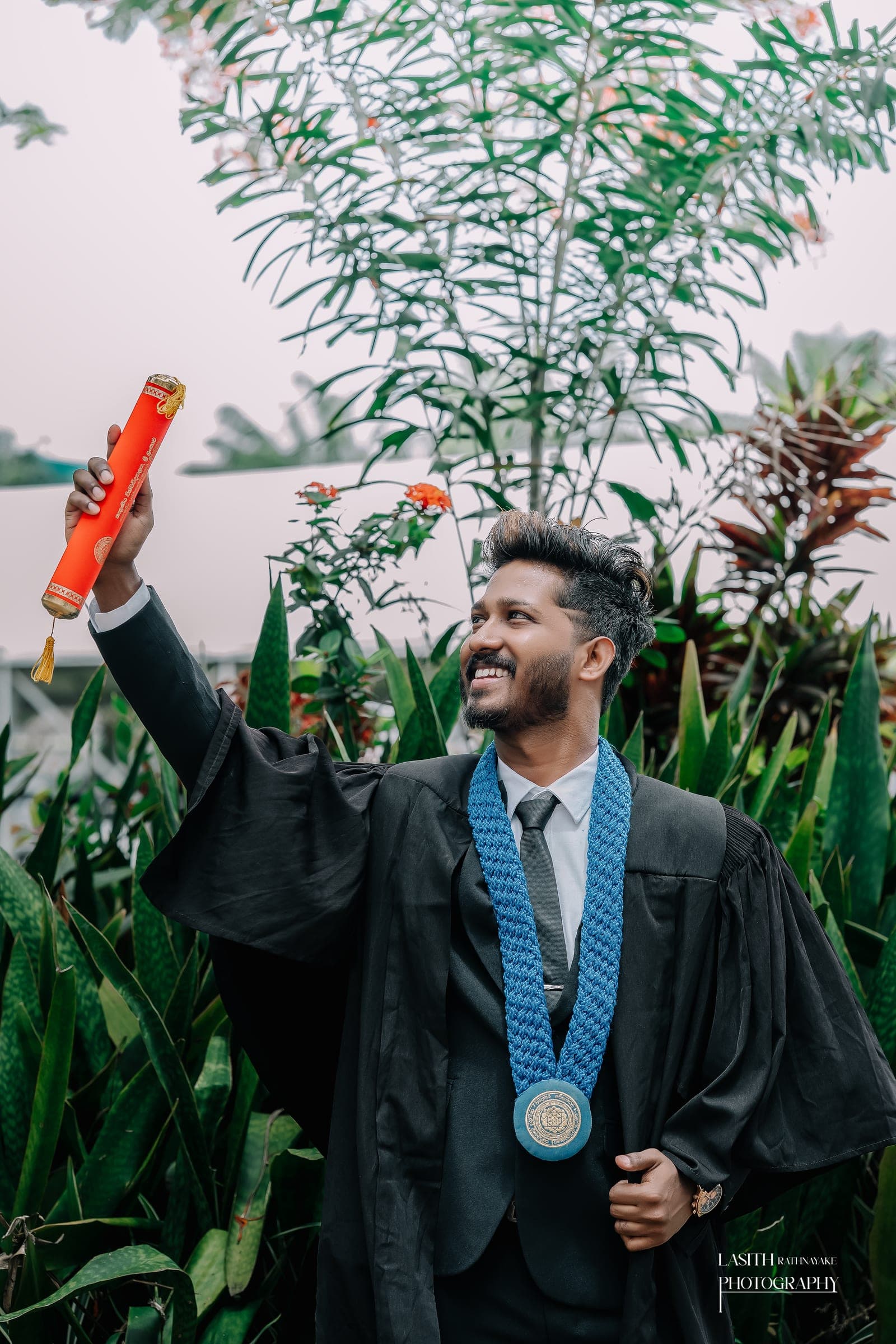 A graduate in his gown with his scroll, photo 4 of 7
