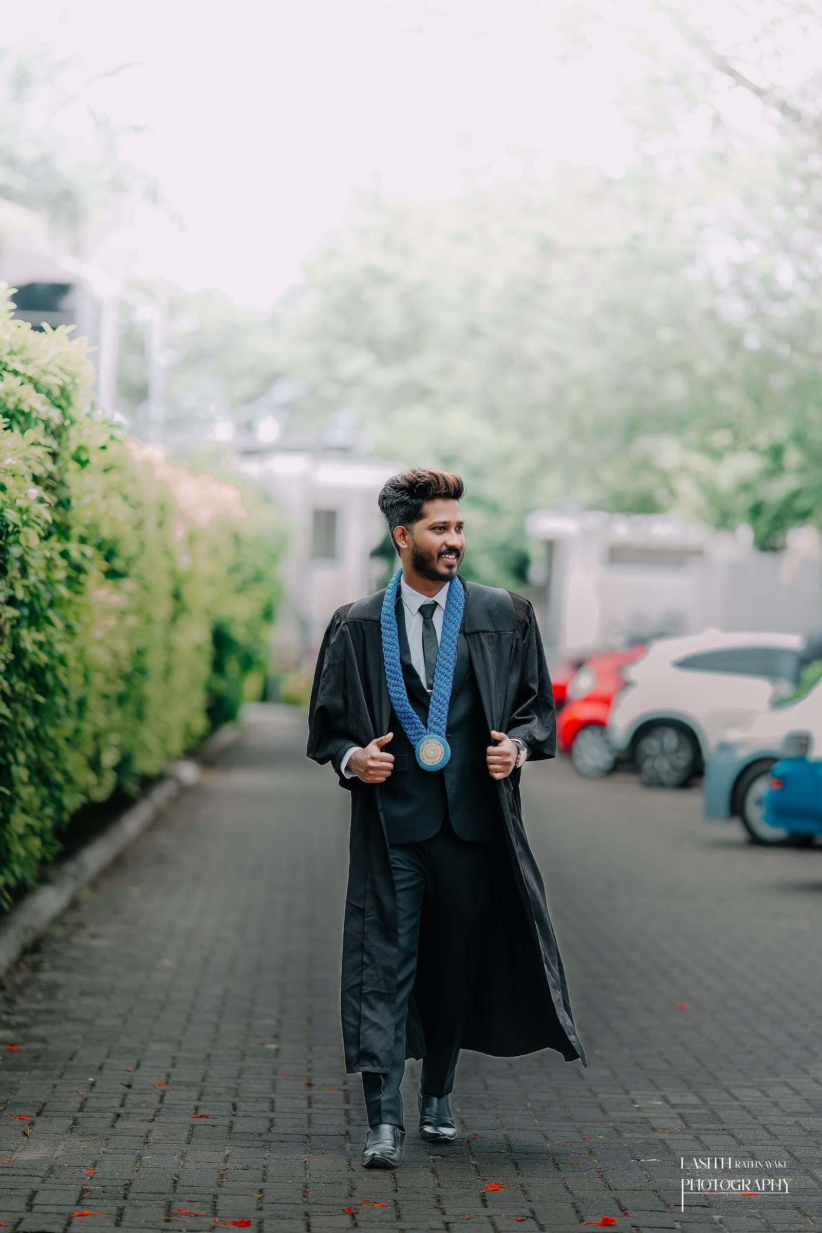 A graduate in his gown with his scroll, photo 5 of 7
